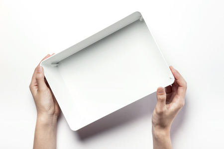 Close up shot of two hands holding and opening white plastic containers-isolated on whiteの写真素材