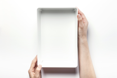Close up shot of two hands holding and opening white plastic containers-isolated on whiteの写真素材