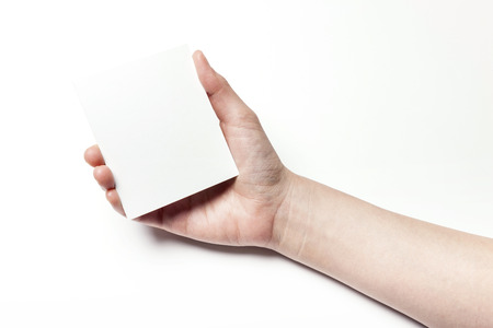 Close up shot of hands holding a piece of white paper-isolated on whiteの写真素材