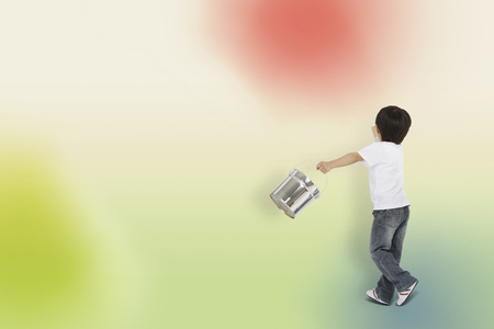 Little Asian boy painting on the wallの写真素材