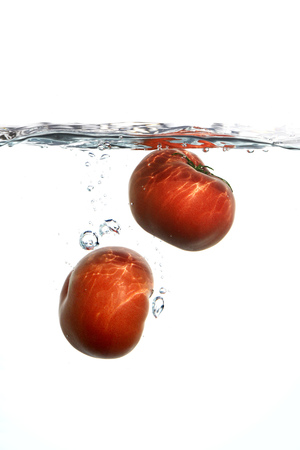 Fresh tomatoes with water splashの写真素材