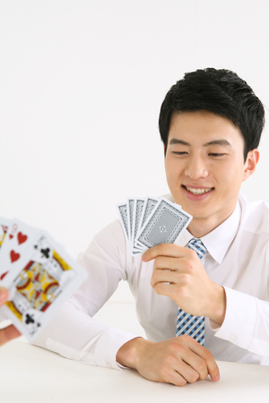 Asian business man with playing cards - isolated on whiteの写真素材