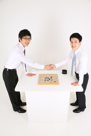 Asian business man playing Asian board game, go - isolated on whiteの写真素材