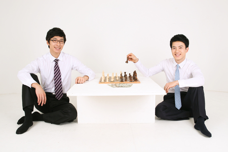 Asian business man with chess pieces - isolated on whiteの写真素材