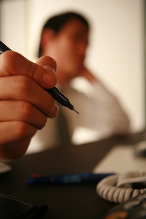 Close up of an Asian businessman holding a penの写真素材