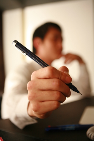 Close up of an Asian businessman holding a penの写真素材