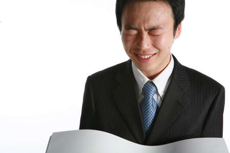 Young Asian businessman holding a bunch of paper - isolated on whiteの写真素材