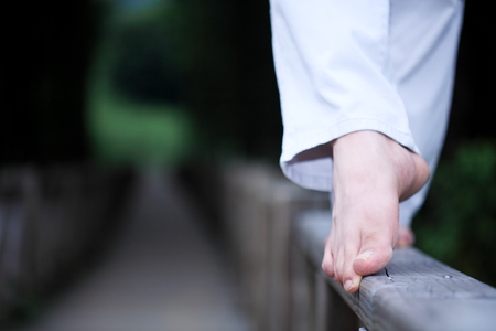 Young Asian man walking barefoot on the wooden bridgeの写真素材