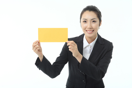 Asian businesswoman holding a small paper piece - isolated on whiteの写真素材