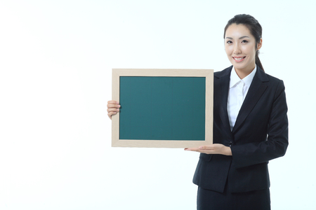 Asian businesswoman holding a chalkboard - isolated on whiteの写真素材