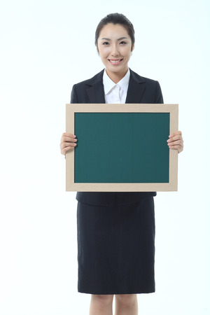 Asian businesswoman holding a chalkboard - isolated on whiteの写真素材