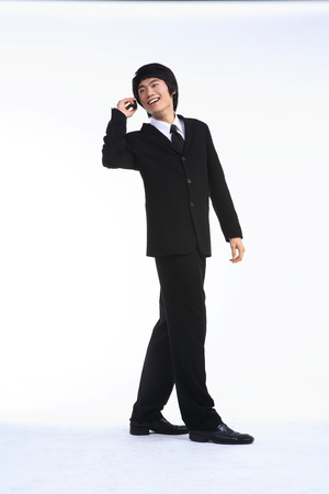 Young Asian businessman with a cellphone - isolated on whiteの写真素材