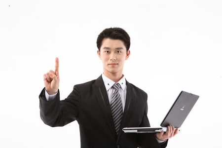 Asian businessman holding a laptop with thumbs up gesture - isolated on whiteの写真素材