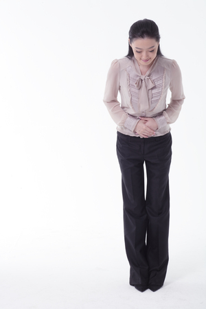 Asian business woman taking a bow - isolated on whiteの写真素材
