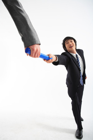 Asian businessman passing the relay baton - isolated on whiteの写真素材