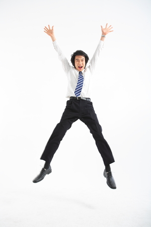 Asian businessman jumping in the studio - isolated on whiteの写真素材
