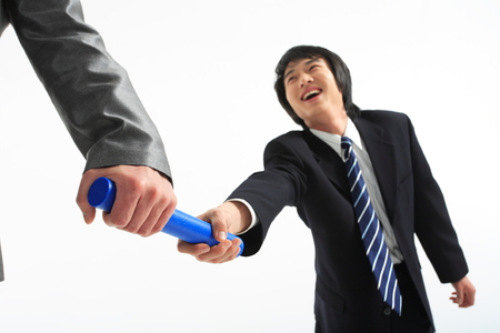 Asian businessman passing the relay baton - isolated on whiteの写真素材