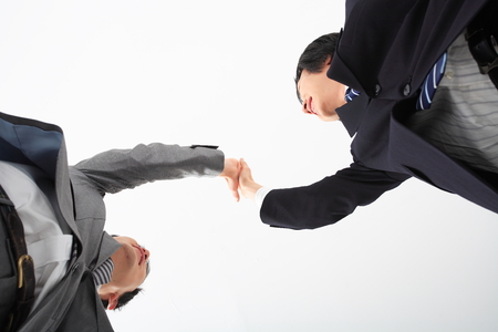 Two Asian businessmen shaking hands - isolated on whiteの写真素材