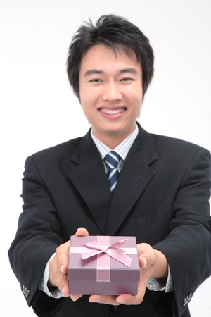 Asian businessman with a gift box - isolated on whiteの写真素材