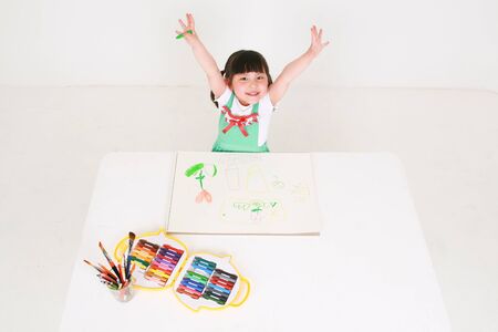 Little Asian girl drawing with crayons - isolated on whiteの写真素材