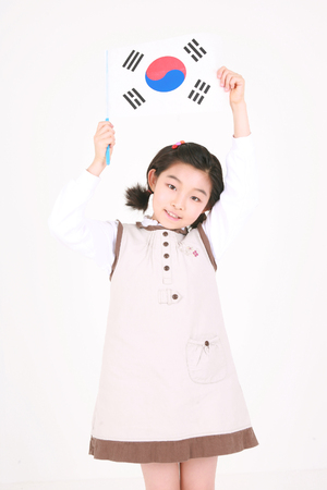 A girl holing up a Korean flag - isolated on whiteの写真素材