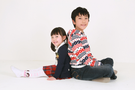A girl and boy sitting back to backのeditorial素材