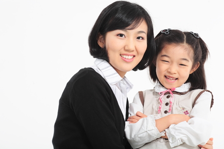 An asian girl and a woman smiling - isolated on whiteの写真素材