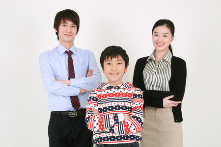 A boy standing with two teachersの写真素材