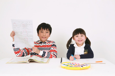 A girl studying colors and a boy studying a bookのeditorial素材