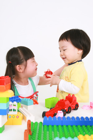 Asians kids playing with toys - isolated on whiteの写真素材
