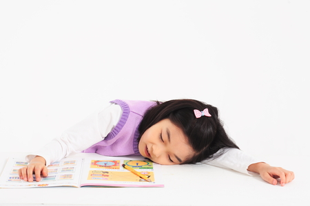 An asian girl studying at table - isolated on whiteの写真素材