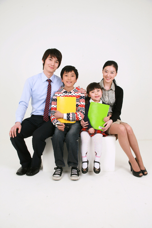 Two teachers and two little boys holding up booksのeditorial素材