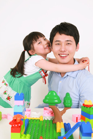 A man and a little girl playing with blocks - isolated on whiteの写真素材