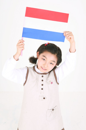 A girl holing up a Dutch flag - isolated on whiteの写真素材