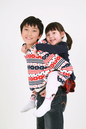 A boy carring a little girl on his backのeditorial素材