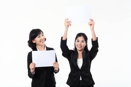Two Asian business women posing in the studio - isolated on whiteの写真素材