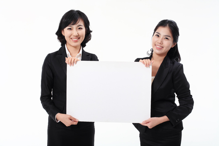 Two Asian business women posing in the studio - isolated on whiteの写真素材