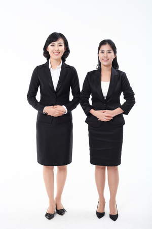 Two Asian business women posing in the studio - isolated on whiteの写真素材