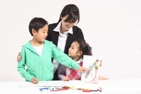 A female teacher teaching two kids drawing - isolated on whiteの写真素材