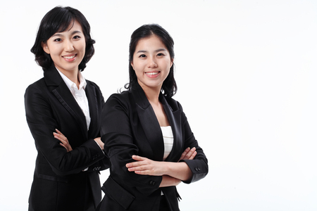 Two Asian business women posing in the studio - isolated on whiteの写真素材
