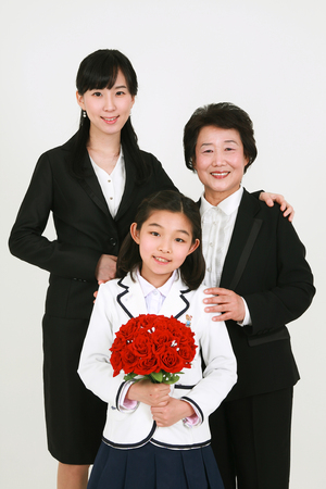 Three generation family celebrating graduation - isolated on whiteの写真素材