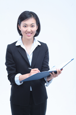 Young Asian businesswoman posing with a folder - isolated on whiteの写真素材