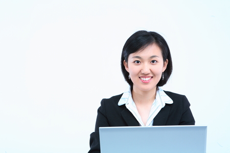 Young Asian businesswoman posing with a laptop - isolated on whiteの写真素材