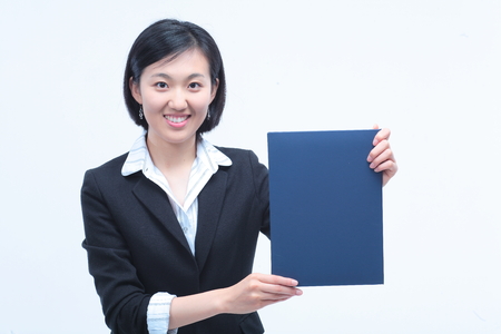 Young Asian businesswoman posing with a folder - isolated on whiteの写真素材