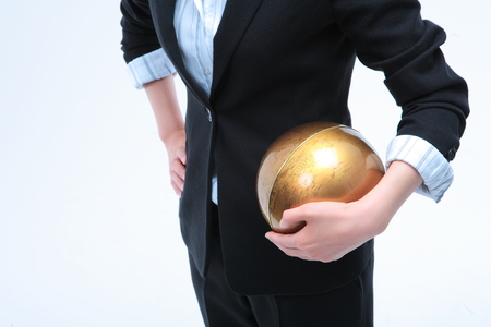 Young Asian businesswoman posing with golden globe - isolated on whiteの写真素材