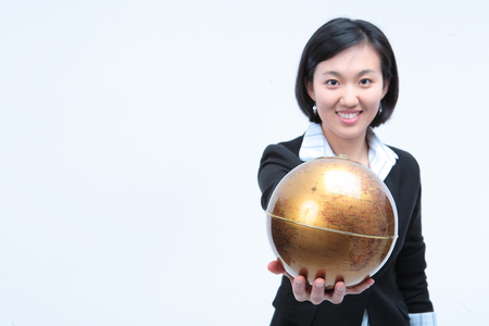 Young Asian businesswoman posing with golden globe - isolated on whiteの写真素材