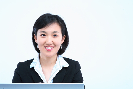 Young Asian businesswoman posing with a laptop - isolated on whiteの写真素材