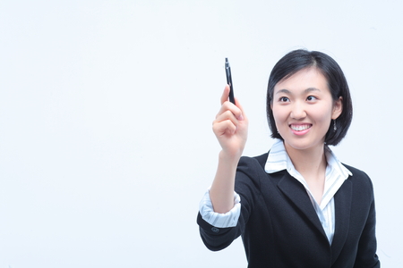 Young Asian businesswoman posing with a pen - isolated on whiteの写真素材