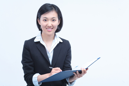 Young Asian businesswoman posing with a folder - isolated on whiteの写真素材