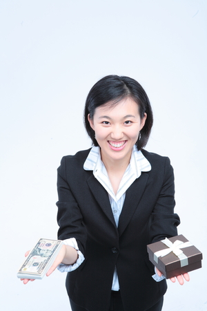 Young Asian businesswoman posing with money and a gift box - isolated on whiteの写真素材